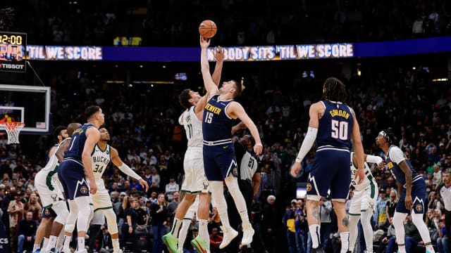 Denver Nuggets center Nikola Jokic (15) and Milwaukee Bucks center Brook Lopez (11) tipoff